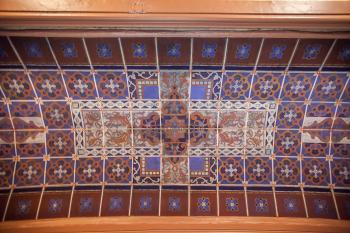 The polychrome ceiling, which has an appearance of tiles, is actually painted gauze over a thick layer of felt